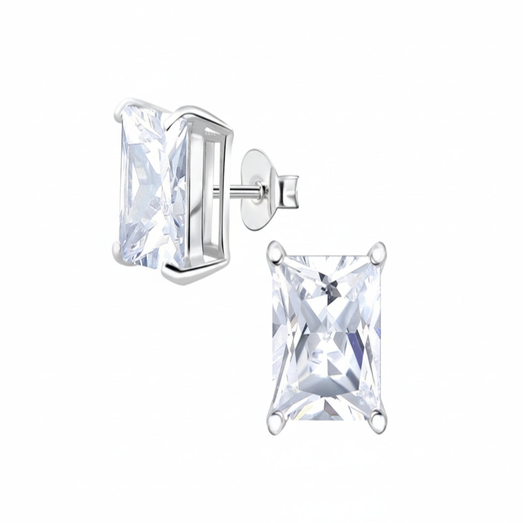 A pair of silver stud earrings with clear rectangular princess-cut gemstones, shown on a plain white background with one earring facing forward and the other angled to show the post and backing.