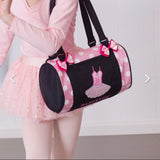 Person wearing a pink dance outfit with a black and pink dance bag featuring a ballet design.