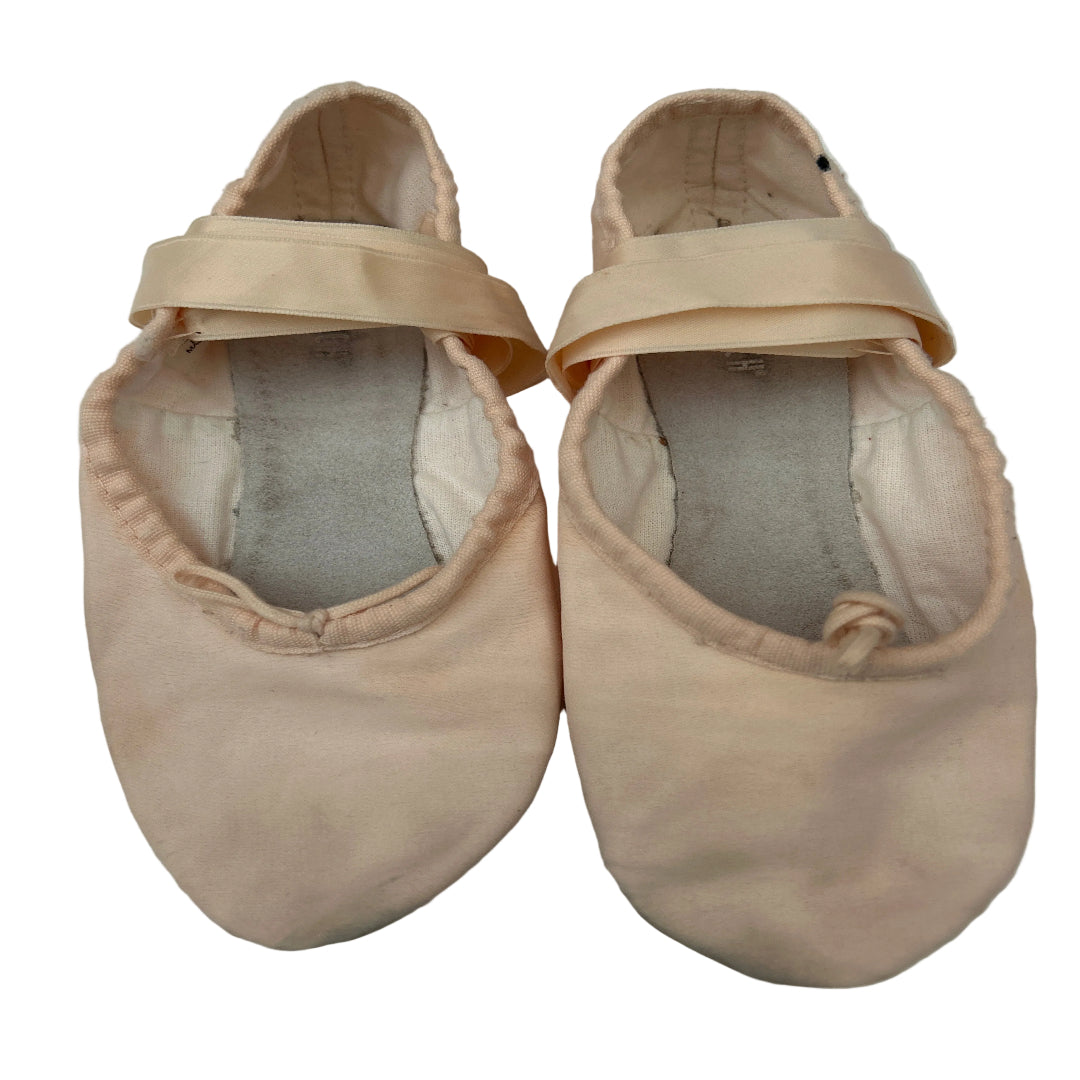 A pair of pink satin ballet shoes with satin straps, shown from a top-down view on a white background.