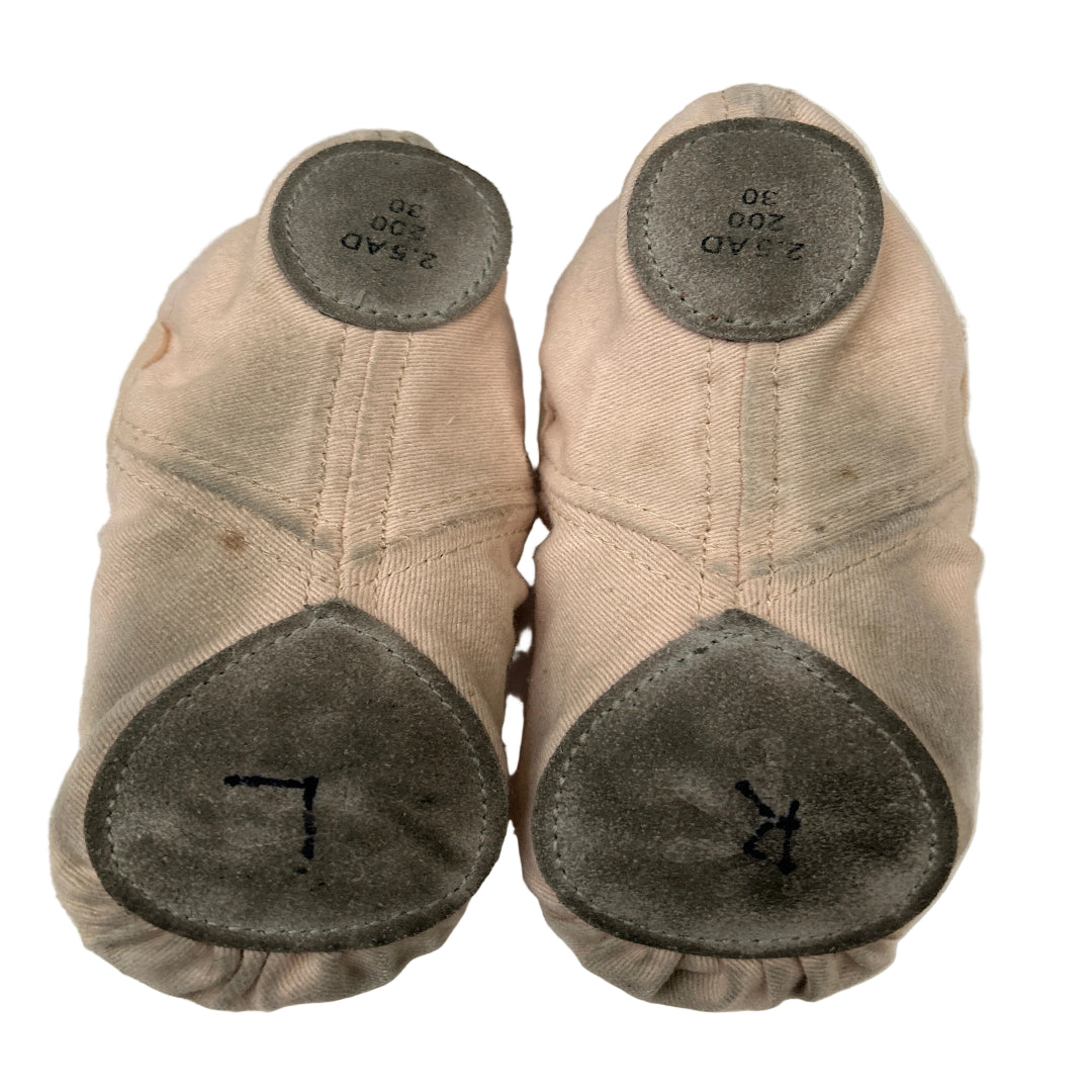 Bottom view of a pair of second hand canvas ballet shoes