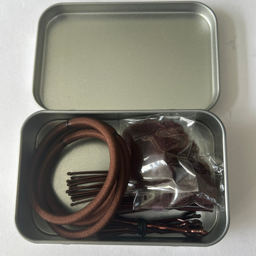 Small silver tin containing brown hair accessories