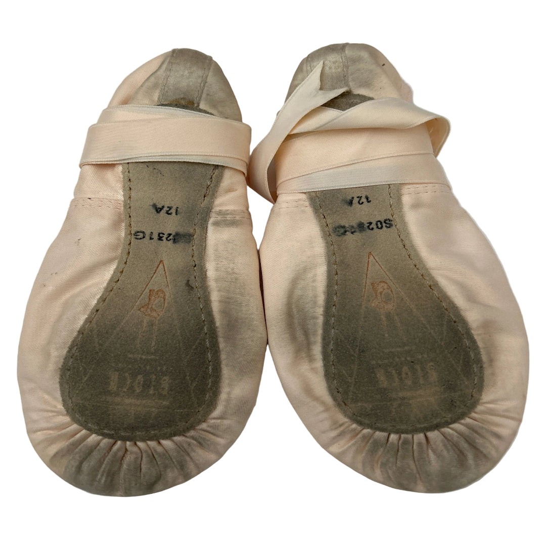 A pair of pink satin ballet shoes with ribbons and full soles, shown on a white background.