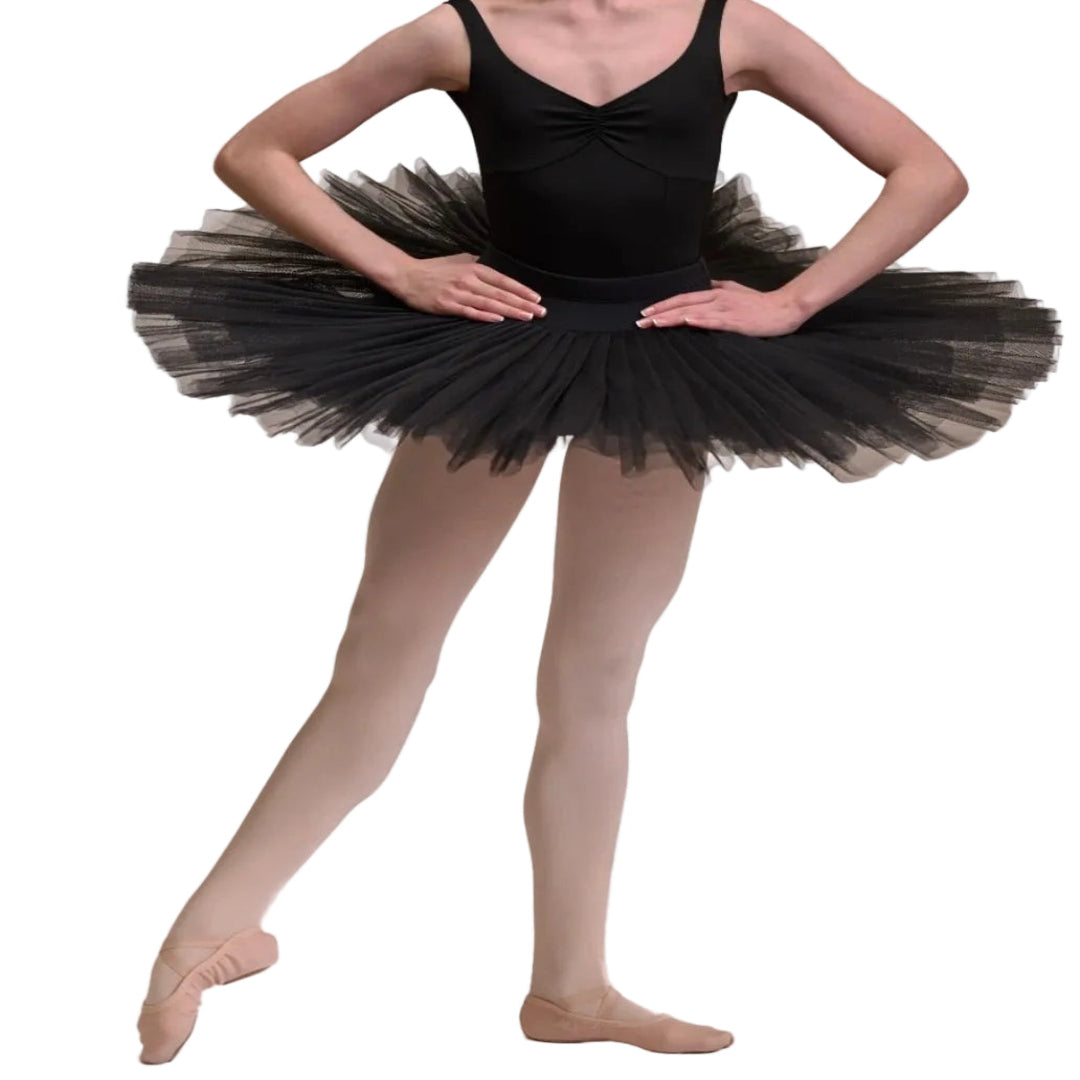 A young ballerina wearing a black sleeveless leotard with a black half tulle tutu