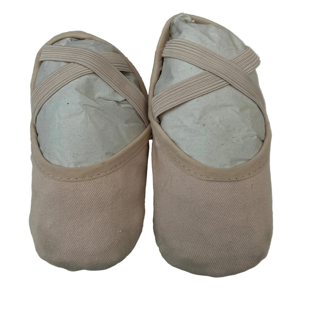 A pair of second hand canvas ballet shoes with criss cross elastic straps