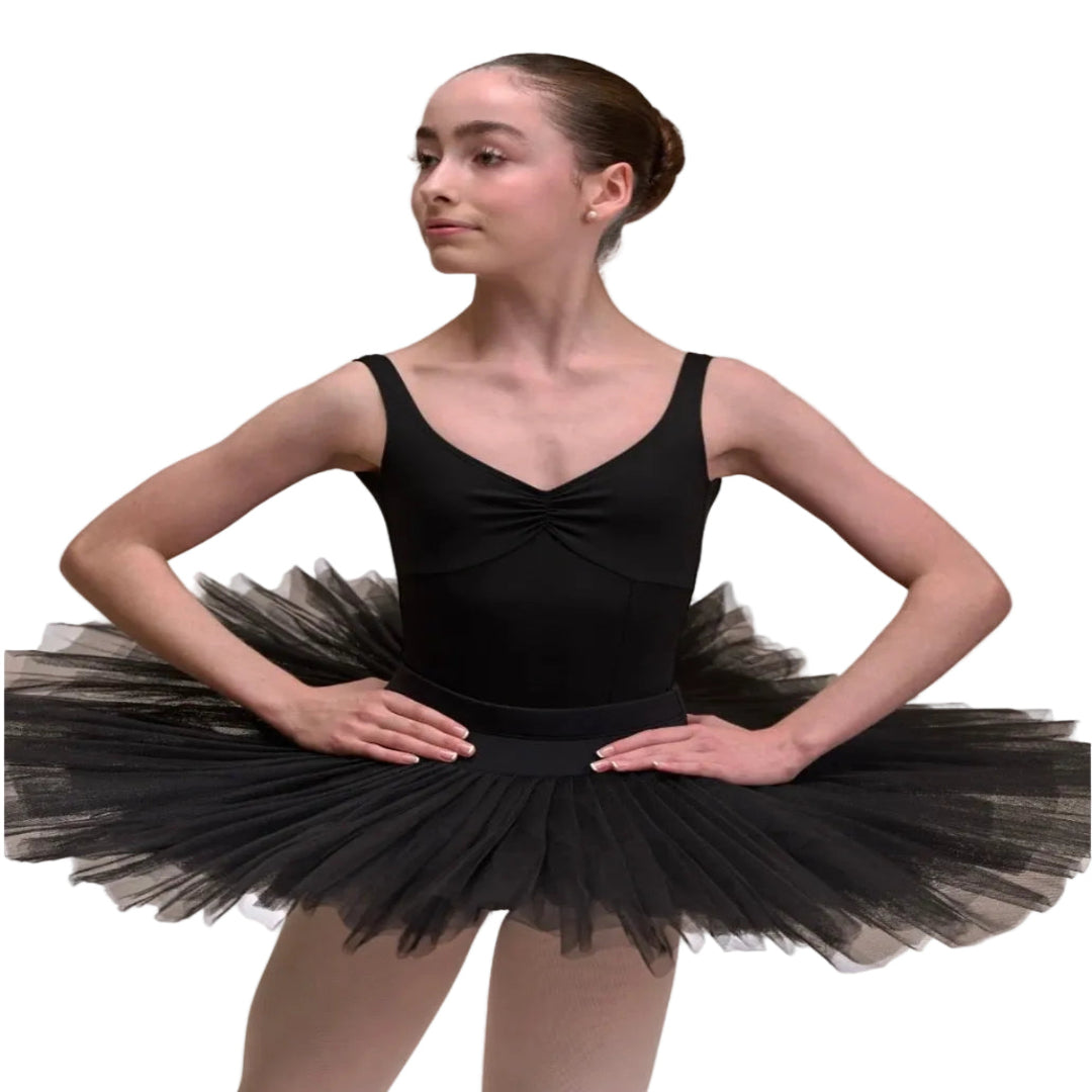 A young ballerina wearing a black sleeveless leotard with a black half tulle tutu