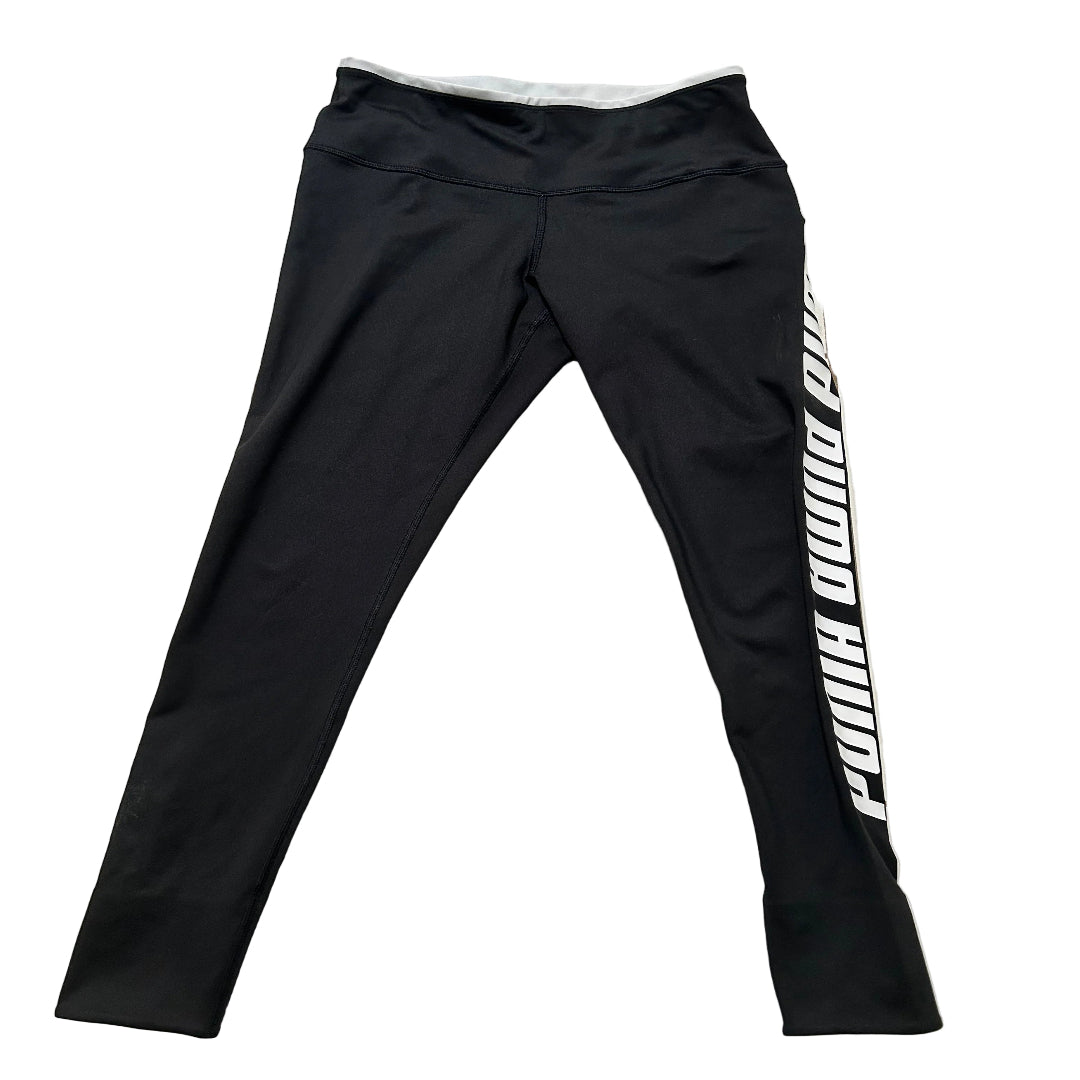 Black athletic leggings with a bold white vertical 'PUMA PUMA PUMA' text print on the left leg, laid flat on a white background