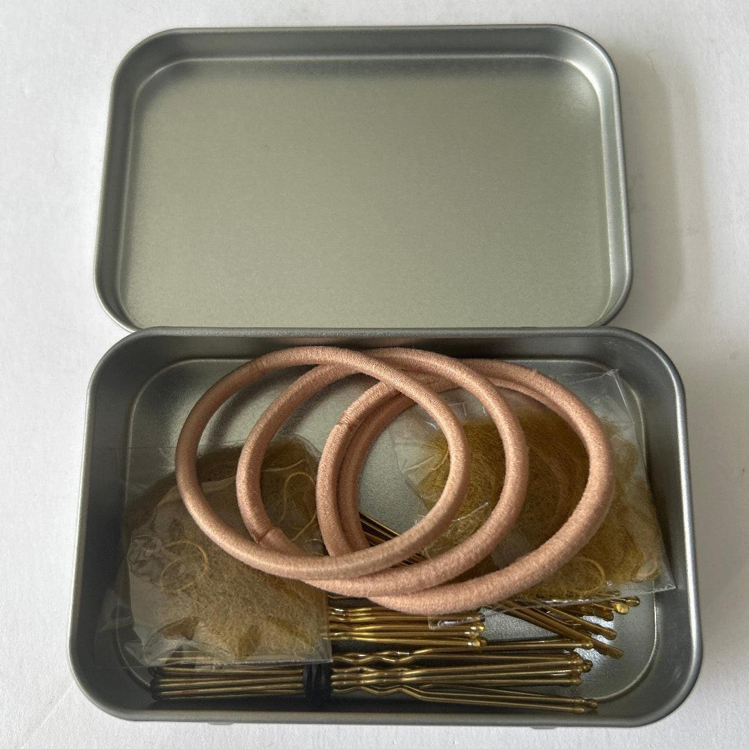 Small silver tin containing blonde hair accessories