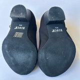 Rear view of a pair of black second hand character shoes