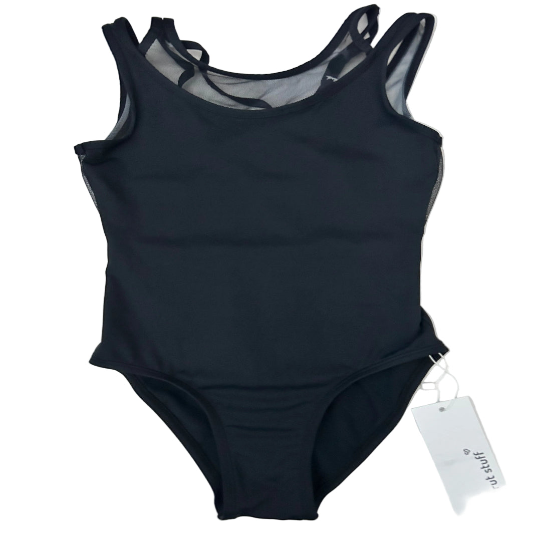 A black leotard with sheer mesh panels and criss cross back straps, laid flat on a white surface with a white brand tag attached.
