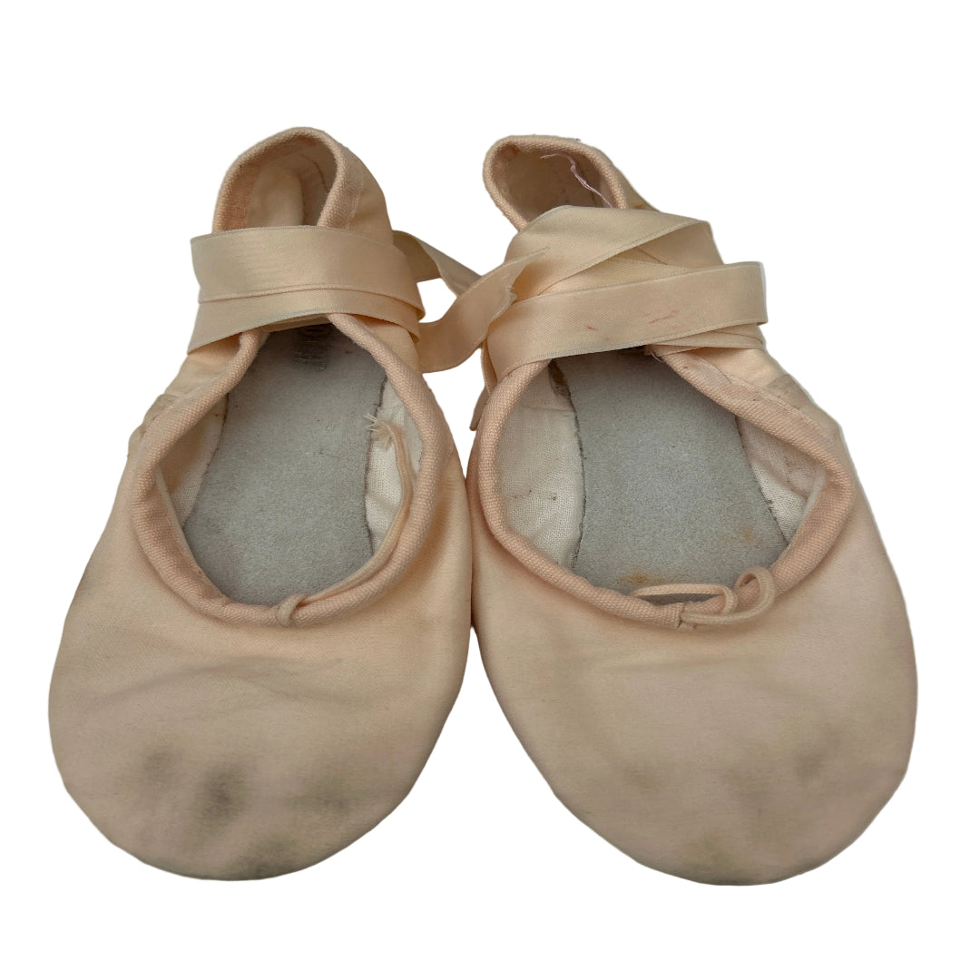 A pair of pink satin ballet shoes with matching ribbon laces, laid flat on a white background.