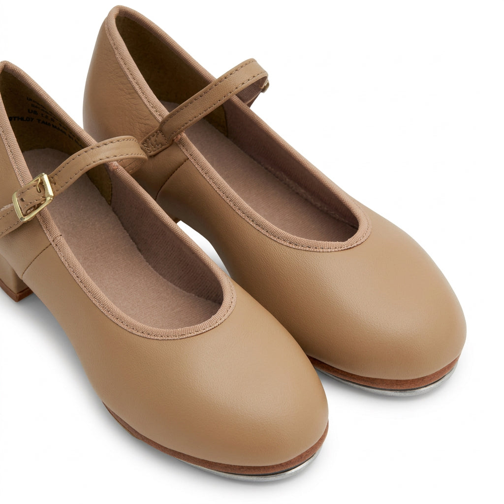 A pair of tan tap shoes on a white background. 